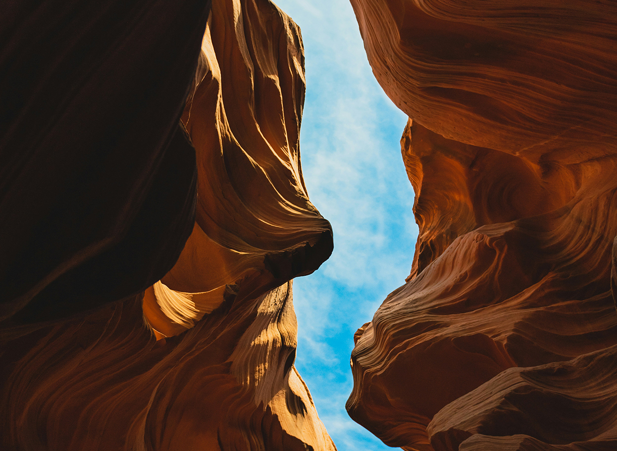 A canyon seen from below. Highlighting a thin clear sky between rock formations. Implying insights. Watson Inc.